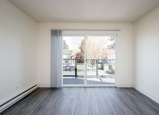 A room with a sliding glass door leading to a parking lot.