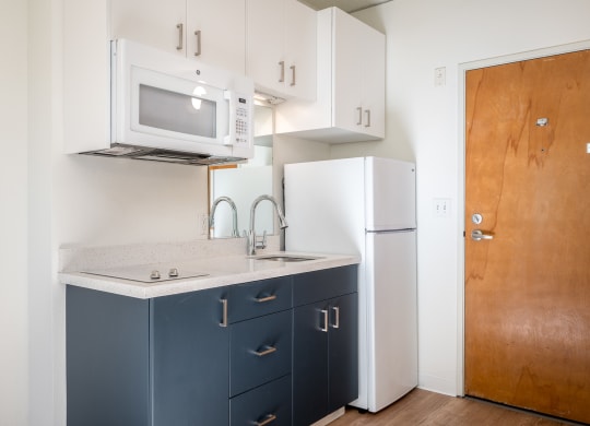 a kitchen with white appliances and blue cabinets