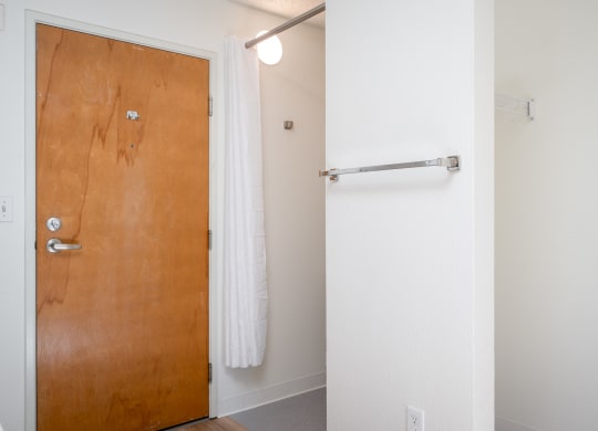 a bathroom with a white shower curtain and a wooden door