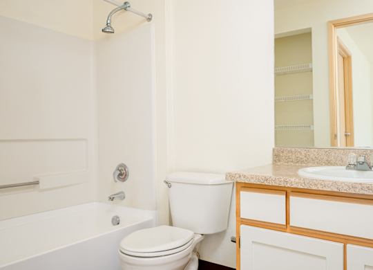 A white toilet sits next to a white sink in a bathroom.