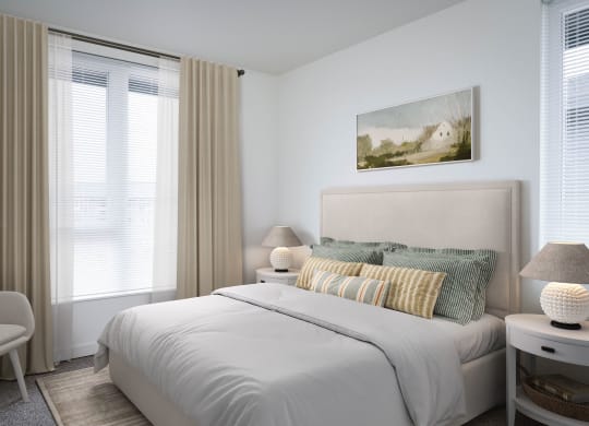 a bedroom with a bed and two windows in a 555 waverly unit