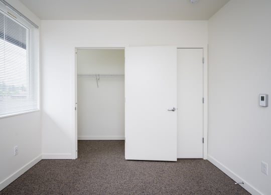 a small bedroom with a closet and a window