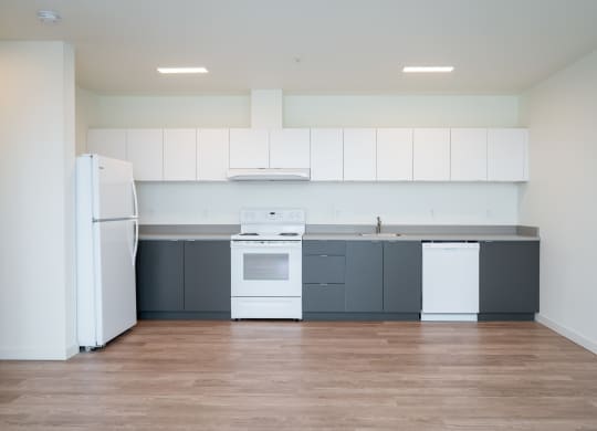 a kitchen with white appliances and gray cabinets