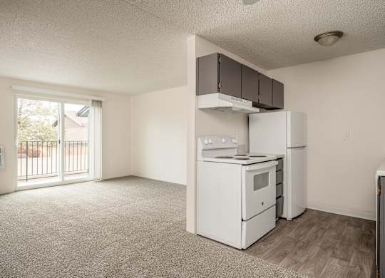 A kitchen with white appliances and a window.