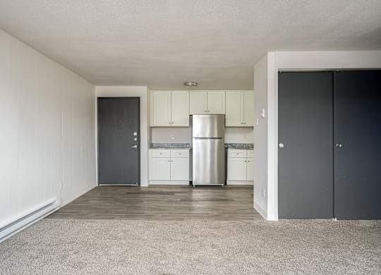 A kitchen with white cabinets and a stainless steel refrigerator.