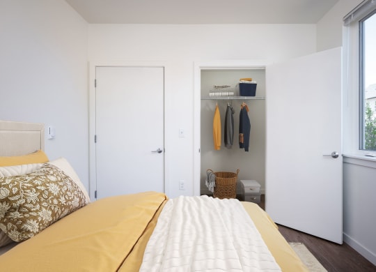 a bedroom with a bed and a closet and a window
