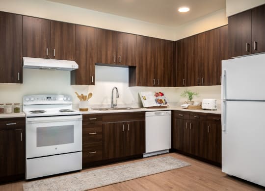 a kitchen with white appliances and dark wood cabinets