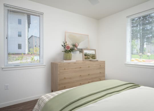 a bedroom with a bed and two windows