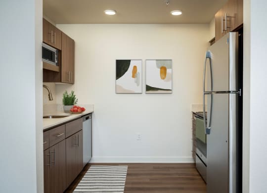 a kitchen with stainless steel appliances and wood flooring