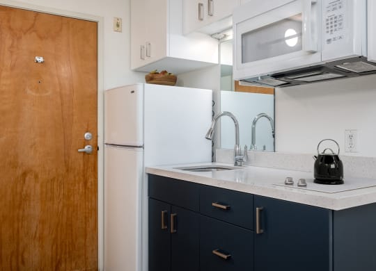 a kitchen with a sink and a refrigerator and a door