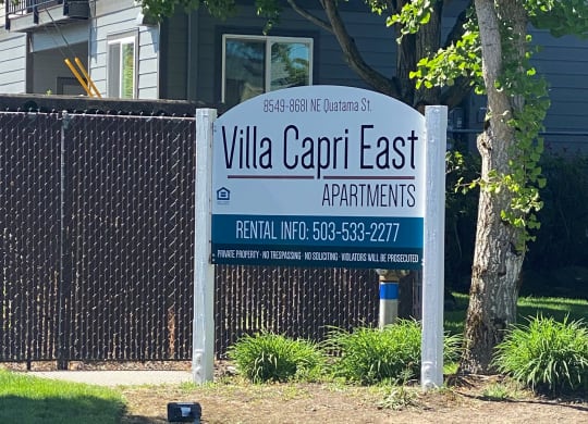 a sign for villa capri east apartments in front of a fence