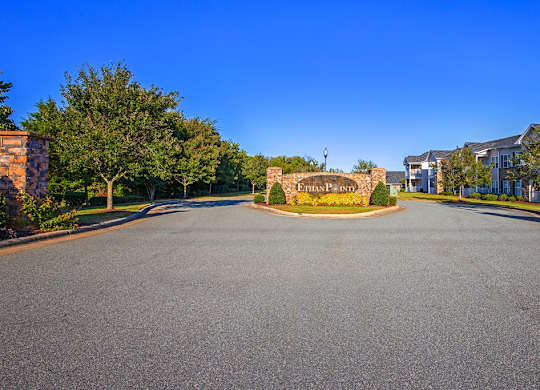 A road leading to a gated community entrance with a sign at Ethan Pointe Apartments, Greensboro, NC