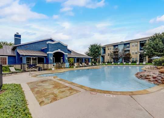 A blue building with a pool in front.