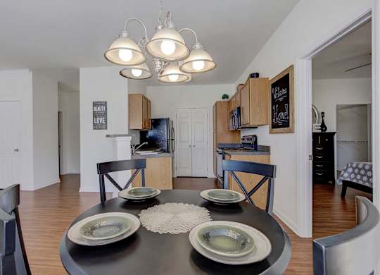 A modern dining room with a black table and chairs at Ethan Pointe Apartments, North Carolina, 27215