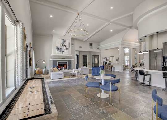 A billiard table is in the middle of a spacious room with a pool table.