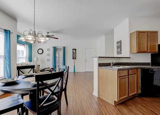 A kitchen with a dining table and chairs is shown at Ethan Pointe Apartments, Greensboro, 27215