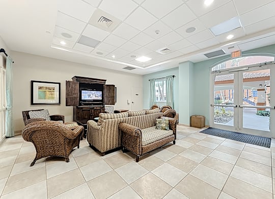 A clubhouse lounge area with a television and couches.