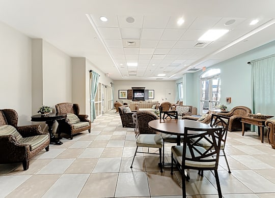 A spacious clubhouse lounge area with a variety of furniture including chairs, couches, and tables.