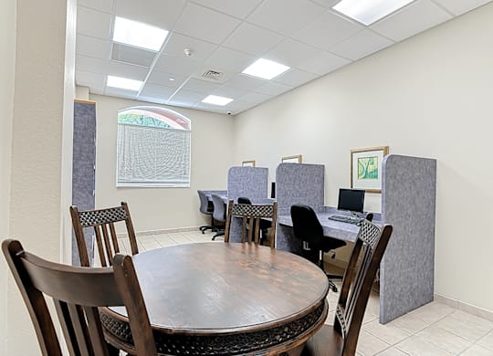 A business center with a table surrounded by chairs.