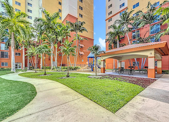 A courtyard with a grassy area and a concrete walkway.