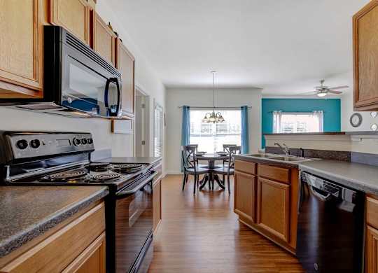 A kitchen with wooden cabinets and a black stove top oven at Ethan Pointe Apartments, Greensboro, NC, 27215