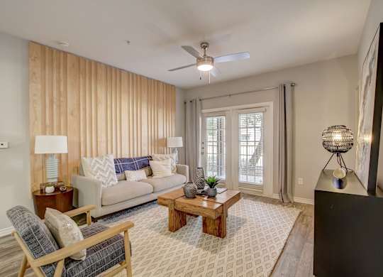 A living room with a couch, chair, and a rug.