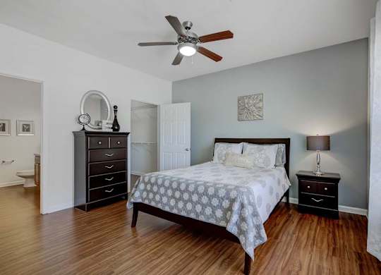 A bedroom with a bed, dresser, and mirror at Ethan Pointe Apartments, Greensboro, North Carolina