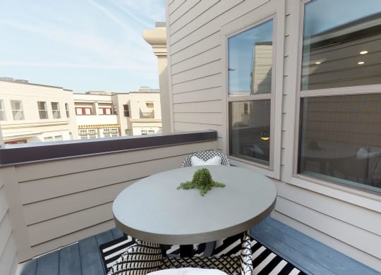 Exterior patio of apartment with small bistro table and chairs on outdoor rug