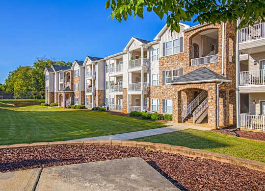 Apartment complex with a walkway in front at Ethan Pointe Apartments, Greensboro