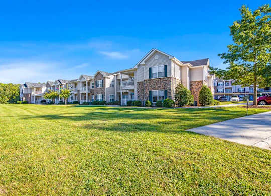 A row of houses with green lawns in front at Ethan Pointe Apartments, Greensboro, 27215