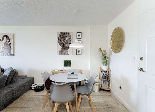 A dining room with a grey table and chairs.