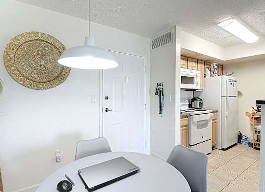 A white kitchen with a table and chairs.