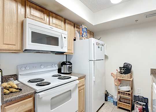 A kitchen with a white stove and white refrigerator.