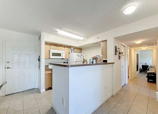 A kitchen with white cabinets and a white door.