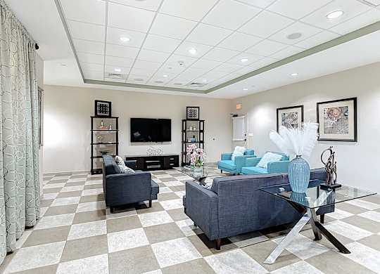 A living room with a checkered floor and a grey couch.