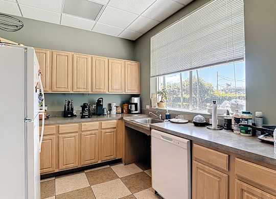 A kitchen with wooden cabinets and a white dishwasher.