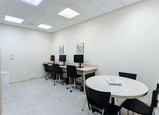 A conference room with a round table and chairs.