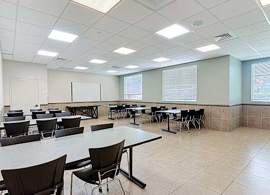 A room with tables and chairs is empty.