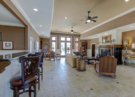 A living room with a fireplace and a bar area at Ethan Pointe Apartments, Greensboro, NC