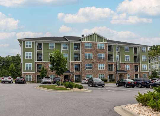 A large apartment complex with a parking lot in front at Foxwood Apartments, Raleigh-Durham, NC, 27616