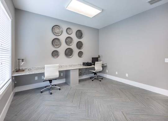 A room with a desk, chairs, and a wall decoration at Foxwood Apartments, Raleigh-Durham, 27616