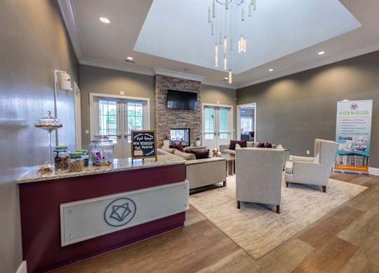 A reception area with a red counter and a white chair at Foxwood Apartments, North Carolina, 27616