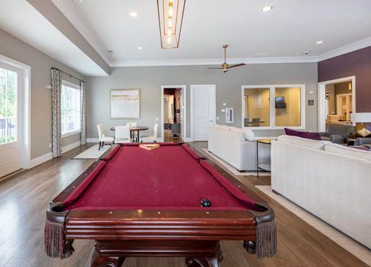 A pool table is in the middle of a room with a ceiling fan at Foxwood Apartments, Raleigh-Durham, NC, 27616