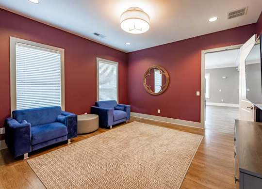 A living room with a blue couch and a round mirror on the wall at Foxwood Apartments, Raleigh-Durham, 27616