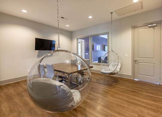 A room with a wooden floor and a hanging chair at Foxwood Apartments, North Carolina