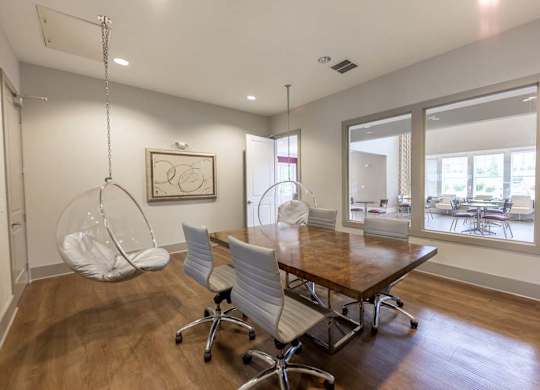 A room with a wooden table and white chairs at Foxwood Apartments, Raleigh-Durham, North Carolina