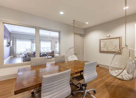 A modern dining room with a wooden table and white chairs at Foxwood Apartments, Raleigh-Durham, 27616