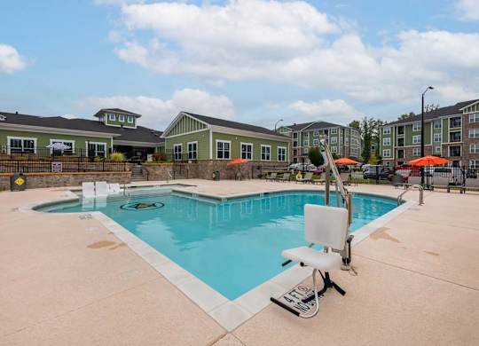 A swimming pool with a slide and a sun lounger at Foxwood Apartments, Raleigh-Durham, NC