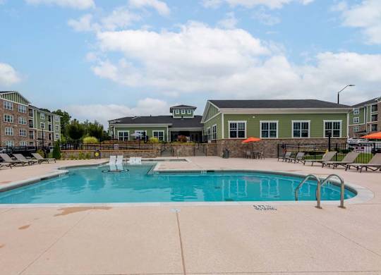 A large swimming pool surrounded by lounge chairs and umbrellas at Foxwood Apartments, Raleigh-Durham, 27616