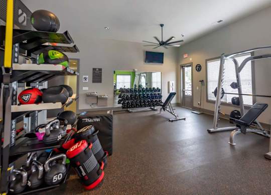 A well-equipped home gym with a variety of exercise equipment at Foxwood Apartments, North Carolina, 27616